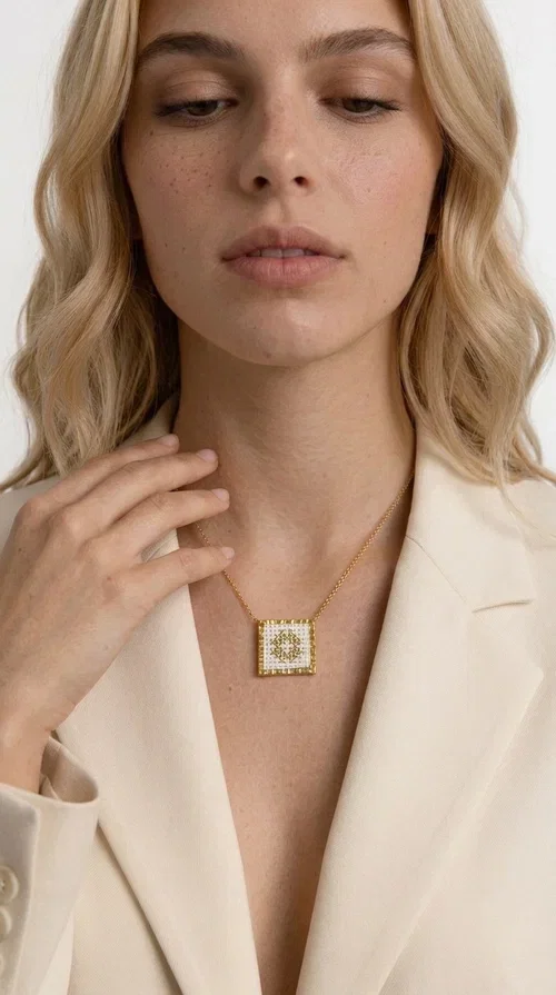 , The embroidered necklace with geometric patterns is a statement piece of jewelry that combines the traditional art of embroidery with a modern, minimal aesthetic. Designed by Greek Jewelry Designer Aikaterini Chalkiadaki, this necklace is a handmade piece with strong character — ideal for women who appreciate authenticity and want to stand out.

The square pendant is adorned with white embroidery in geometric motifs inspired by folk tradition, while the gold-toned brass frame adds warmth and elevates the level of elegance. The gold-tone chain blends softly into the overall look, creating a piece of jewelry that suits casual looks just as well as formal occasions.

Wear it over a white t-shirt or under a blazer for an effortless chic look. It also makes a wonderful gift for women who love handmade jewelry with a Greek identity.