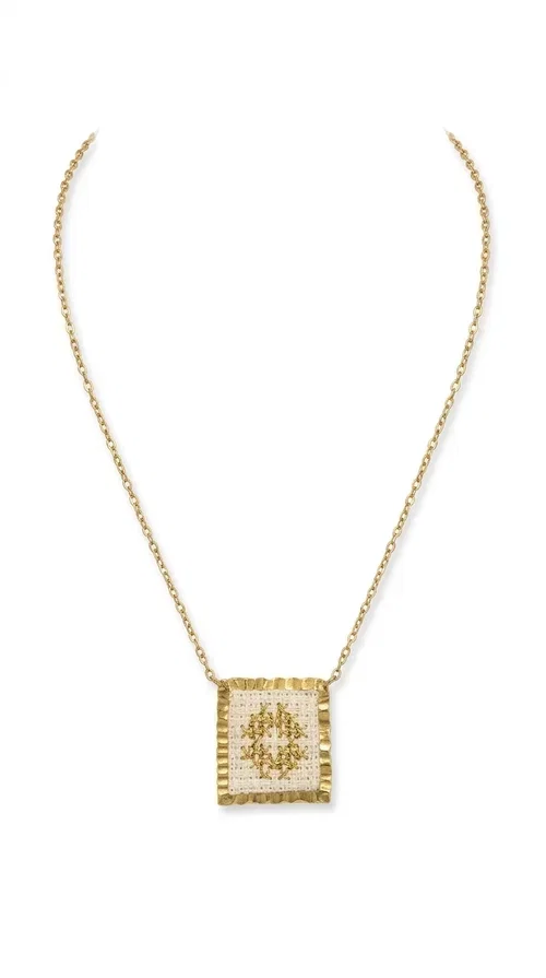 , The embroidered necklace with geometric patterns is a statement piece of jewelry that combines the traditional art of embroidery with a modern, minimal aesthetic. Designed by Greek Jewelry Designer Aikaterini Chalkiadaki, this necklace is a handmade piece with strong character — ideal for women who appreciate authenticity and want to stand out.

The square pendant is adorned with white embroidery in geometric motifs inspired by folk tradition, while the gold-toned brass frame adds warmth and elevates the level of elegance. The gold-tone chain blends softly into the overall look, creating a piece of jewelry that suits casual looks just as well as formal occasions.

Wear it over a white t-shirt or under a blazer for an effortless chic look. It also makes a wonderful gift for women who love handmade jewelry with a Greek identity.