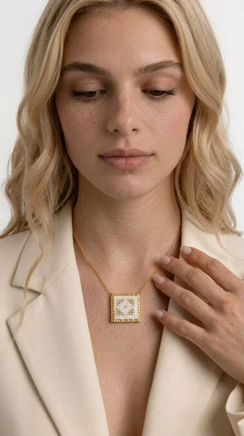 , The embroidered statement necklace with geometric patterns is a handmade piece of jewelry that combines the traditional art of embroidery with a modern, striking result. Designed by Greek Jewelry Designer Aikaterini Chalkiadaki, this unique necklace is an ideal choice for those who love jewelry with character and soul.

The pendant necklace features a square motif in white with detailed geometric embroidery, while the golden brass frame and delicate chain add elegance and a sense of luxury. The interplay of white fabric and gold details creates a look that suits both casual and formal outfits equally well.

Perfect as a gift or to complete your own look, this necklace pairs beautifully with white, ecru, or monochrome outfits. It can be worn alone as a statement piece or combined with thinner necklaces for a layered look.