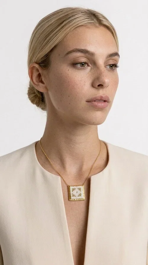 , The embroidered statement necklace with geometric patterns is a handmade piece of jewelry that combines the traditional art of embroidery with a modern, striking result. Designed by Greek Jewelry Designer Aikaterini Chalkiadaki, this unique necklace is an ideal choice for those who love jewelry with character and soul.

The pendant necklace features a square motif in white with detailed geometric embroidery, while the golden brass frame and delicate chain add elegance and a sense of luxury. The interplay of white fabric and gold details creates a look that suits both casual and formal outfits equally well.

Perfect as a gift or to complete your own look, this necklace pairs beautifully with white, ecru, or monochrome outfits. It can be worn alone as a statement piece or combined with thinner necklaces for a layered look.