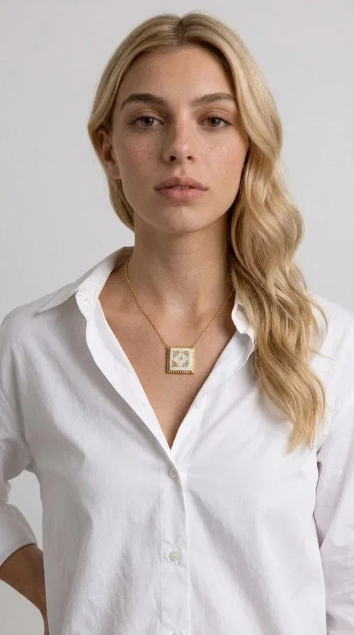 , The embroidered statement necklace with geometric patterns is a handmade piece of jewelry that combines the traditional art of embroidery with a modern, striking result. Designed by Greek Jewelry Designer Aikaterini Chalkiadaki, this unique necklace is an ideal choice for those who love jewelry with character and soul.

The pendant necklace features a square motif in white with detailed geometric embroidery, while the golden brass frame and delicate chain add elegance and a sense of luxury. The interplay of white fabric and gold details creates a look that suits both casual and formal outfits equally well.

Perfect as a gift or to complete your own look, this necklace pairs beautifully with white, ecru, or monochrome outfits. It can be worn alone as a statement piece or combined with thinner necklaces for a layered look.