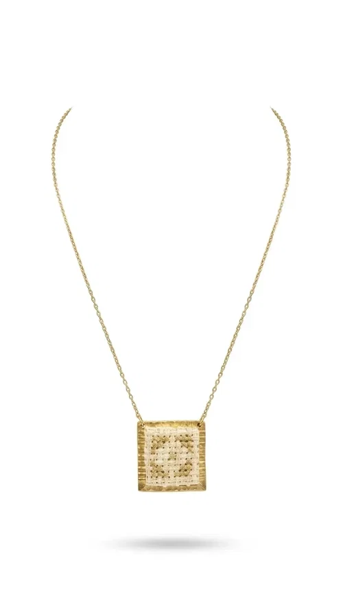, The embroidered statement necklace with geometric patterns is a handmade piece of jewelry that combines the traditional art of embroidery with a modern, striking result. Designed by Greek Jewelry Designer Aikaterini Chalkiadaki, this unique necklace is an ideal choice for those who love jewelry with character and soul.

The pendant necklace features a square motif in white with detailed geometric embroidery, while the golden brass frame and delicate chain add elegance and a sense of luxury. The interplay of white fabric and gold details creates a look that suits both casual and formal outfits equally well.

Perfect as a gift or to complete your own look, this necklace pairs beautifully with white, ecru, or monochrome outfits. It can be worn alone as a statement piece or combined with thinner necklaces for a layered look.