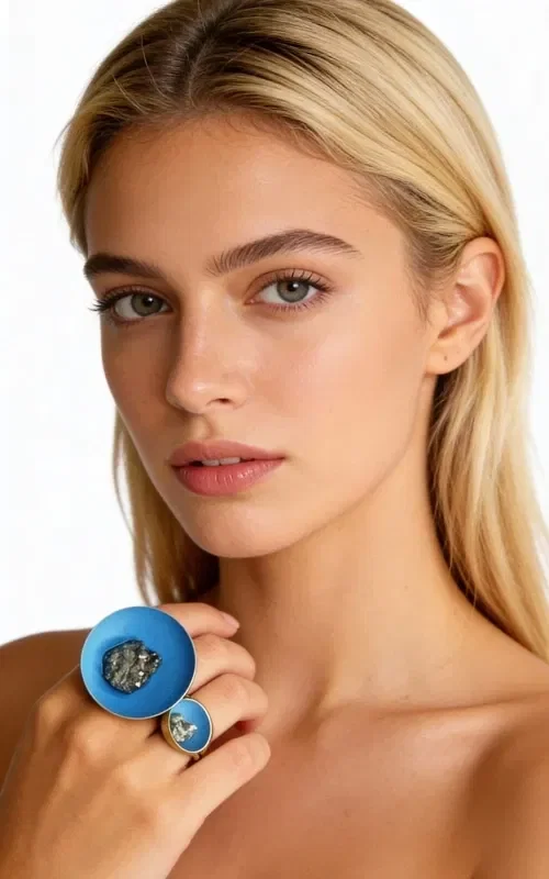 , An impressive statement ring that combines the natural beauty of pyrite with an intense chalky blue color, designed by Greek Jewelry Designer Aikaterini Chalkiadaki. This large handmade ring features two different spheres that create a modern, asymmetric aesthetic.

The larger sphere holds a big pyrite crystal, while the smaller one is adorned with a smaller crystal, creating a striking composition that catches the eye. The chalky light blue color gives it a unique vintage vibe, while the brass ensures durability and long-lasting wear.

This handmade women's ring is ideal for those who love bold, statement-making jewelry. It pairs perfectly with casual and bohemian looks, adding an eclectic touch to any outfit.