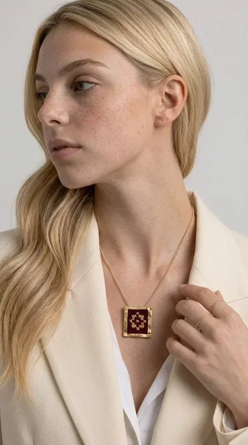 , The embroidered burgundy necklace with geometric patterns is a statement piece that combines the traditional art of embroidery with a contemporary aesthetic, creating a unique result that instantly catches the eye.

Designed by Greek Jewelry Designer Aikaterini Chalkiadaki, this handmade necklace features a square brass pendant with deep burgundy fabric and a striking embroidered geometric motif inspired by Greek folk tradition. The gold-toned brass metal frame surrounds the embroidery, giving the piece a vintage, luxurious feel. The delicate gold-tone chain highlights the pendant, making it the ultimate focal point of any look.

Ideal for pairing with a casual white shirt, a dress, or elegant attire for an evening out, this necklace is equally suited to everyday and formal occasions. It also makes an excellent gift choice for loved ones who appreciate unique, handmade jewelry with a Greek soul.