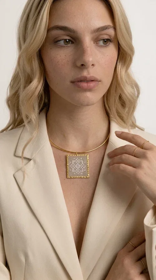 , The statement necklace embroidered with geometric patterns is a jewelry piece that instantly grabs attention — bold, handmade and full of character. Designed by Greek Jewelry Designer Aikaterini Chalkiadaki, it combines the tradition of embroidery art with a modern aesthetic result that suits both day and evening wear. The brass collar holds a square embroidered pendant in deep burgundy color, decorated with delicate geometric motifs inspired by Greek folk tradition.

This necklace is not just an accessory — it's a style statement. The embroidered fabric in burgundy shade, framed by golden brass, creates a striking contrast that enhances every outfit. Ideal to be worn over a simple white or ecru shirt, or to complete an evening look, it offers that unique balance between boho and minimal style.