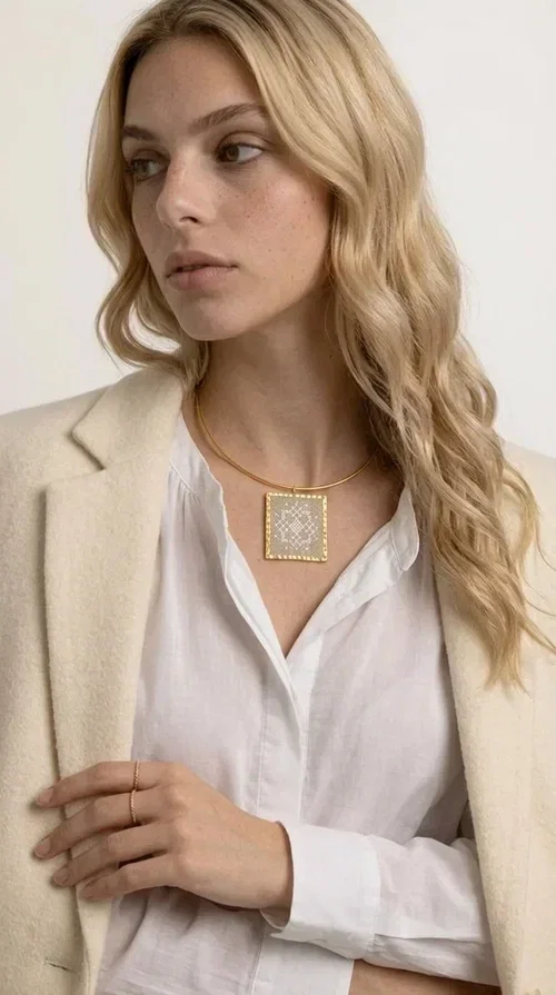 , The statement necklace embroidered with geometric patterns is a jewelry piece that instantly grabs attention — bold, handmade and full of character. Designed by Greek Jewelry Designer Aikaterini Chalkiadaki, it combines the tradition of embroidery art with a modern aesthetic result that suits both day and evening wear. The brass collar holds a square embroidered pendant in deep burgundy color, decorated with delicate geometric motifs inspired by Greek folk tradition.

This necklace is not just an accessory — it's a style statement. The embroidered fabric in burgundy shade, framed by golden brass, creates a striking contrast that enhances every outfit. Ideal to be worn over a simple white or ecru shirt, or to complete an evening look, it offers that unique balance between boho and minimal style.