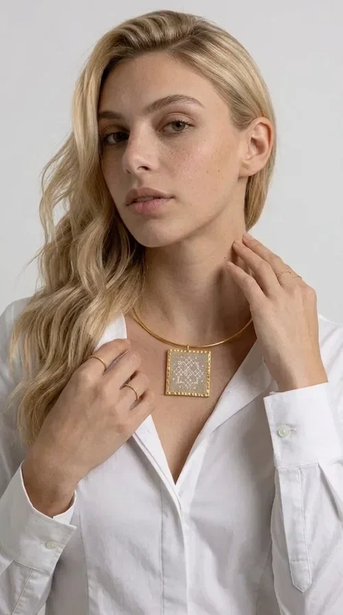 , The statement necklace embroidered with geometric patterns is a jewelry piece that instantly grabs attention — bold, handmade and full of character. Designed by Greek Jewelry Designer Aikaterini Chalkiadaki, it combines the tradition of embroidery art with a modern aesthetic result that suits both day and evening wear. The brass collar holds a square embroidered pendant in deep burgundy color, decorated with delicate geometric motifs inspired by Greek folk tradition.

This necklace is not just an accessory — it's a style statement. The embroidered fabric in burgundy shade, framed by golden brass, creates a striking contrast that enhances every outfit. Ideal to be worn over a simple white or ecru shirt, or to complete an evening look, it offers that unique balance between boho and minimal style.