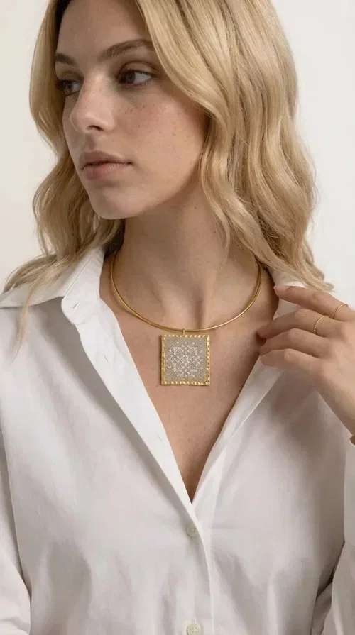 , The statement necklace embroidered with geometric patterns is a jewelry piece that instantly grabs attention — bold, handmade and full of character. Designed by Greek Jewelry Designer Aikaterini Chalkiadaki, it combines the tradition of embroidery art with a modern aesthetic result that suits both day and evening wear. The brass collar holds a square embroidered pendant in deep burgundy color, decorated with delicate geometric motifs inspired by Greek folk tradition.

This necklace is not just an accessory — it's a style statement. The embroidered fabric in burgundy shade, framed by golden brass, creates a striking contrast that enhances every outfit. Ideal to be worn over a simple white or ecru shirt, or to complete an evening look, it offers that unique balance between boho and minimal style.