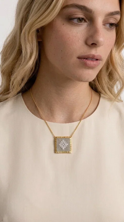 , An embroidered necklace that combines the traditional art of embroidery with a modern aesthetic — ideal for every woman who loves handmade jewelry with character.

Designed by Greek Jewelry Designer Aikaterini Chalkiadaki, this statement necklace in a cream shade features a square brass pendant with a gold finish, adorned with delicate embroidered geometric patterns on fabric. The gold-tone box chain completes the composition harmoniously, offering an air of elegance and uniqueness. Each piece is the result of handcrafted work, with attention to every detail.

This necklace pairs perfectly with casual looks as well as more formal outfits — try it over a white t-shirt for a bohemian style or combine it with a blazer for a more sophisticated look. Ideal as a gift for women who appreciate handmade jewelry and Greek craftsmanship.