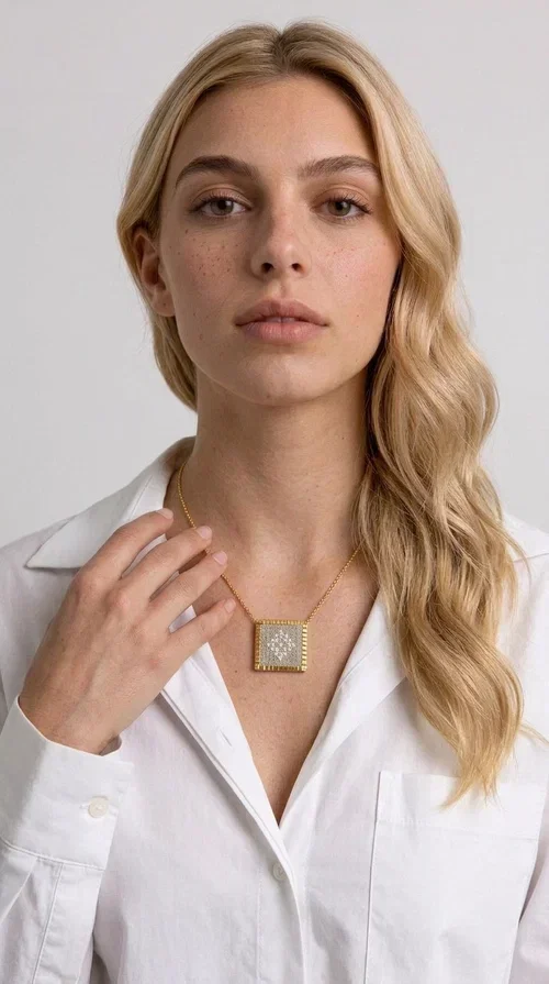 , An embroidered necklace that combines the traditional art of embroidery with a modern aesthetic — ideal for every woman who loves handmade jewelry with character.

Designed by Greek Jewelry Designer Aikaterini Chalkiadaki, this statement necklace in a cream shade features a square brass pendant with a gold finish, adorned with delicate embroidered geometric patterns on fabric. The gold-tone box chain completes the composition harmoniously, offering an air of elegance and uniqueness. Each piece is the result of handcrafted work, with attention to every detail.

This necklace pairs perfectly with casual looks as well as more formal outfits — try it over a white t-shirt for a bohemian style or combine it with a blazer for a more sophisticated look. Ideal as a gift for women who appreciate handmade jewelry and Greek craftsmanship.