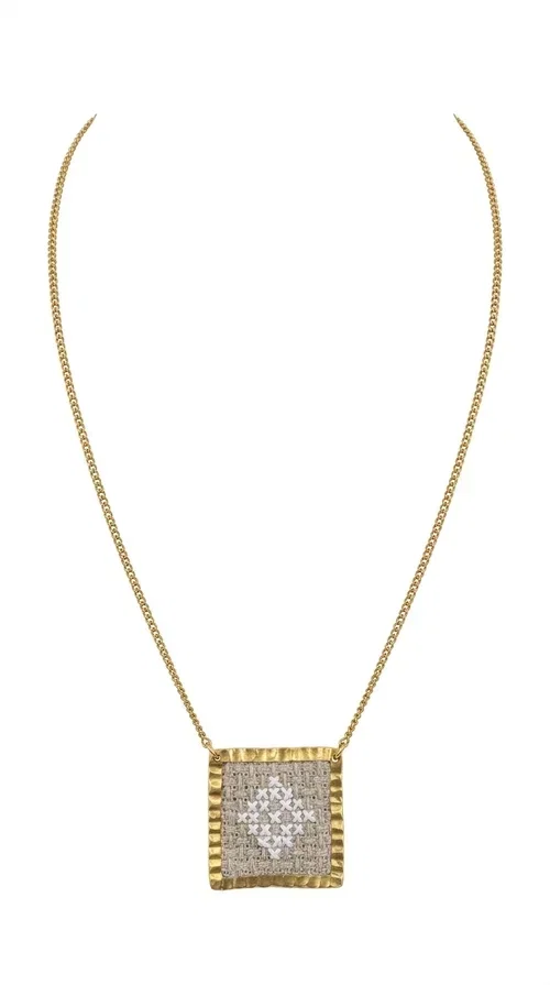 , An embroidered necklace that combines the traditional art of embroidery with a modern aesthetic — ideal for every woman who loves handmade jewelry with character.

Designed by Greek Jewelry Designer Aikaterini Chalkiadaki, this statement necklace in a cream shade features a square brass pendant with a gold finish, adorned with delicate embroidered geometric patterns on fabric. The gold-tone box chain completes the composition harmoniously, offering an air of elegance and uniqueness. Each piece is the result of handcrafted work, with attention to every detail.

This necklace pairs perfectly with casual looks as well as more formal outfits — try it over a white t-shirt for a bohemian style or combine it with a blazer for a more sophisticated look. Ideal as a gift for women who appreciate handmade jewelry and Greek craftsmanship.