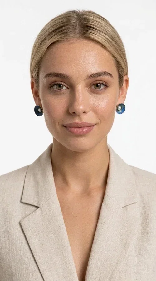 , The handmade stud earrings with a pearl in deep blue enamel are an ideal choice for every woman seeking elegance with character. Designed by Greek Jewelry Designer Aikaterini Chalkiadaki, these unique earrings combine the traditional technique of enamel with the timeless grace of the pearl, creating a result that impresses without being overwhelming.

The circular brass body is covered with handmade enamel in rich shades of blue — from deep navy to cobalt — with subtle color variations reminiscent of the ocean depths. At the center, a white pearl adds finesse and contrast, elevating the whole piece to another level. The result is a statement piece of jewelry that suits an everyday look just as well as a wedding or formal outfit.