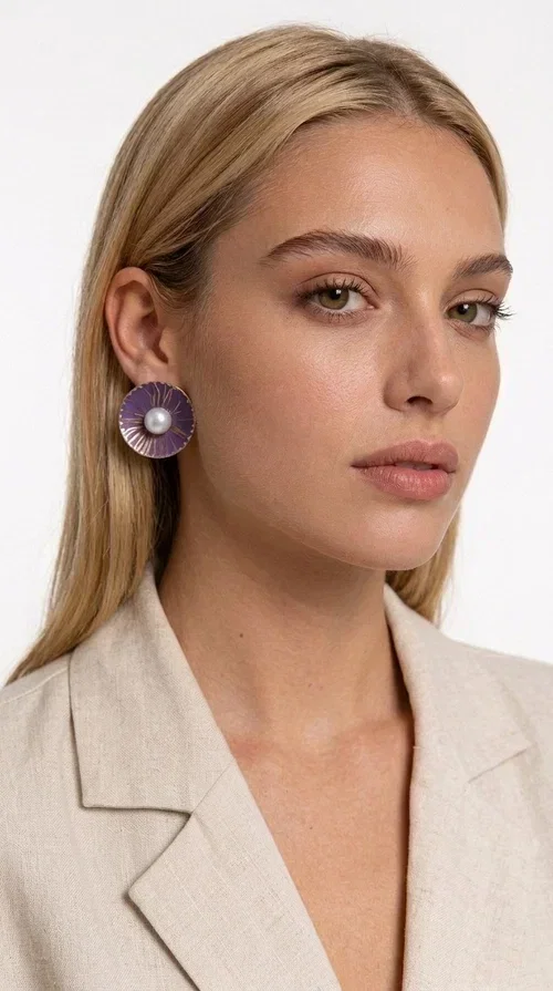 , Stud earrings with pearls in a purple hue are an elegant choice that combines the feel of vintage aesthetics with modern design. Designed by Greek Jewelry Designer Aikaterini Chalkiadaki, these handmade earrings are a distinctive addition to the collection of any woman who loves authentic jewelry.

The circular shape with its ribbed brass surface, covered in deep purple enamel, showcases a shimmering pearl at its center, creating an effect reminiscent of a blooming flower. This refined design suits both everyday outfits and formal occasions, from corporate meetings to weddings and christenings.

These purple pearl earrings make an ideal gift for loved ones, as they are handmade with attention to detail and crafted from quality materials that ensure long-lasting wear.