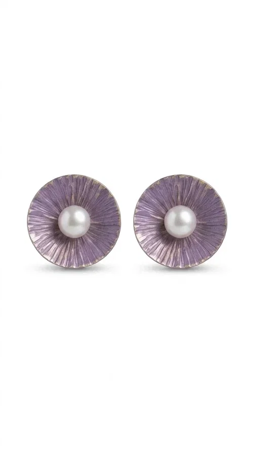 , Stud earrings with pearls in a purple hue are an elegant choice that combines the feel of vintage aesthetics with modern design. Designed by Greek Jewelry Designer Aikaterini Chalkiadaki, these handmade earrings are a distinctive addition to the collection of any woman who loves authentic jewelry.

The circular shape with its ribbed brass surface, covered in deep purple enamel, showcases a shimmering pearl at its center, creating an effect reminiscent of a blooming flower. This refined design suits both everyday outfits and formal occasions, from corporate meetings to weddings and christenings.

These purple pearl earrings make an ideal gift for loved ones, as they are handmade with attention to detail and crafted from quality materials that ensure long-lasting wear.