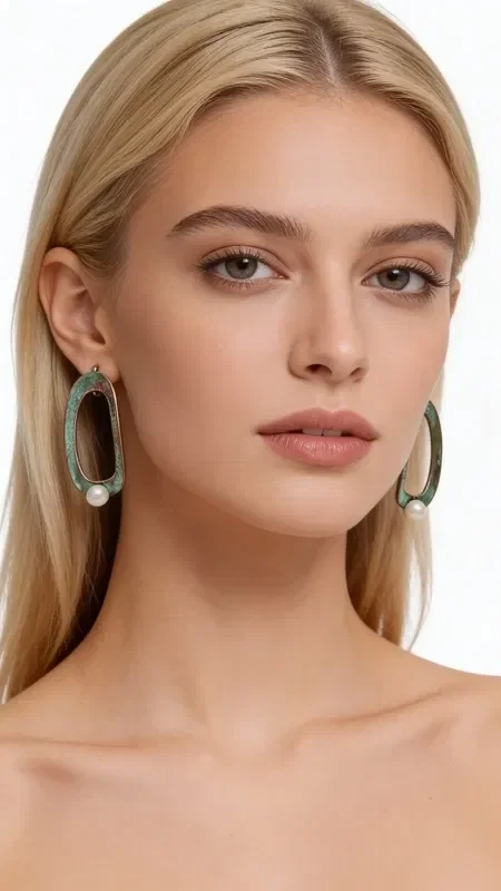 , Discover the unique beauty of these stud earrings with pearls that combine finesse with a modern aesthetic. Designed by Greek Jewelry Designer Aikaterini Chalkiadaki, these striking earrings feature an original oval design with copper and green patina that creates a vintage aesthetic.

Each earring features a delicate pearl at the bottom that adds elegance and femininity to the geometric shape. The green patina on the copper creates a unique texture and color gradient that makes each piece one of a kind. These handmade earrings are ideal for women who love statement jewelry with an artistic character.