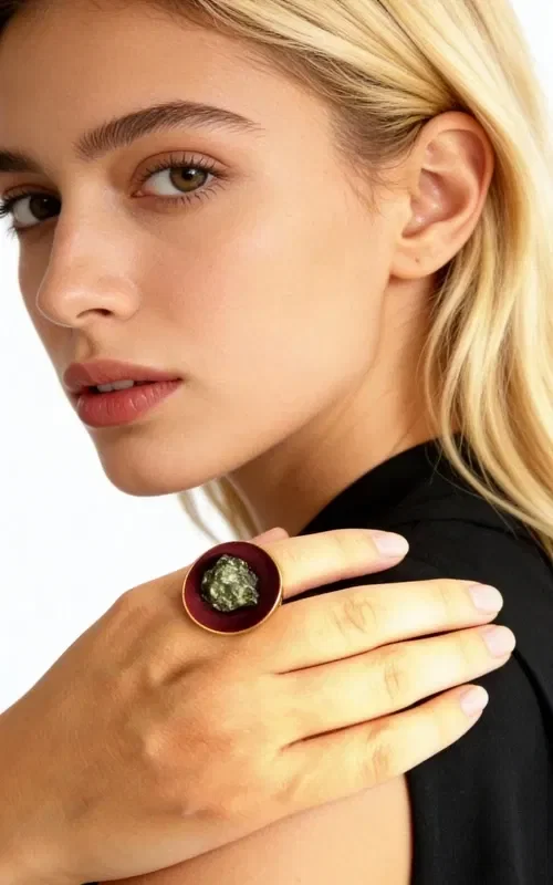, Discover the magic of handmade jewelry with this striking women's ring featuring pyrite in a burgundy hue. Designed by Greek Jewelry Designer Aikaterini Chalkiadaki, this ring combines traditional Greek craftsmanship with a modern aesthetic.

The large ring features a round surface in a bold burgundy color, at the center of which shines natural pyrite with its characteristic golden metallic sheen. The brass base offers stability and comfort when worn, while the handmade construction guarantees the uniqueness of every piece.

This statement ring is ideal for completing both everyday and evening outfits, adding a touch of authentic Greek artistry to your style. Store in a dry place and clean with a soft cloth to preserve the jewelry's shine.